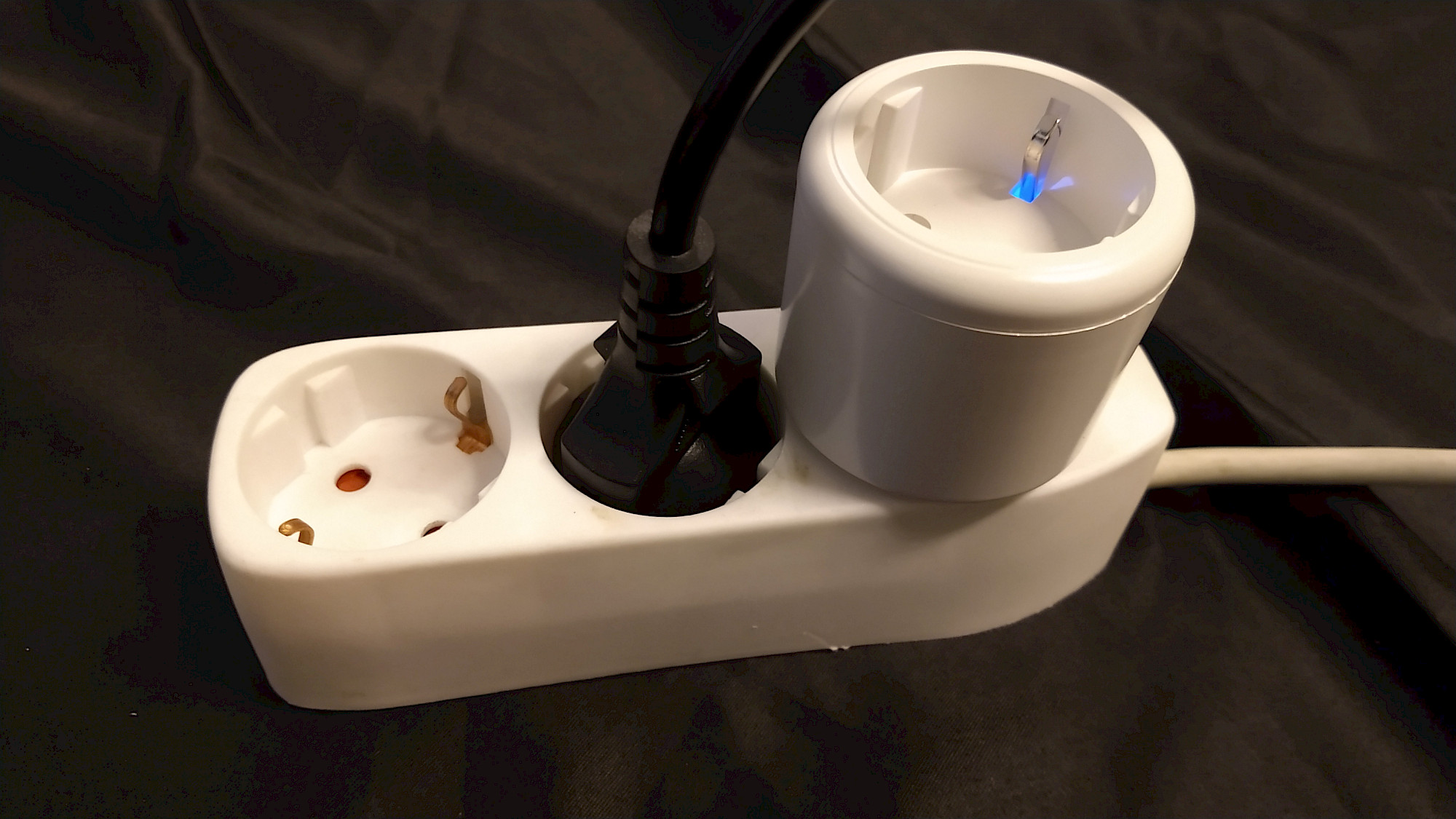 SURFOU BSD48 in der Steckdosenleiste neben einem Standard-Schuko-Stecker